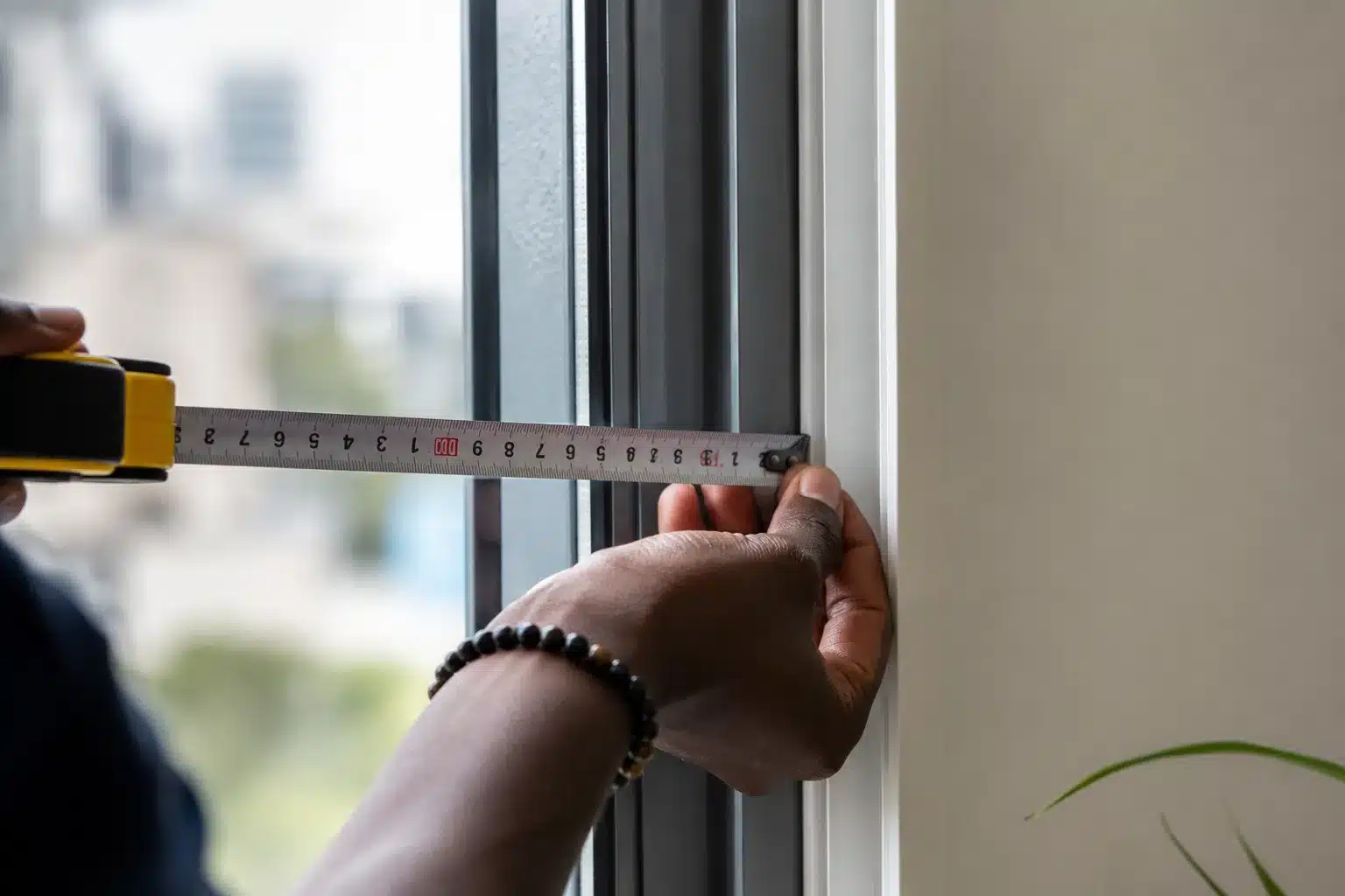 Measuring a window before curtain installation