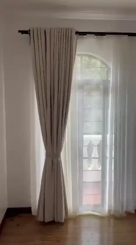 A short walkthrough of a neutral curtain and sheer treatment above a timber floor.