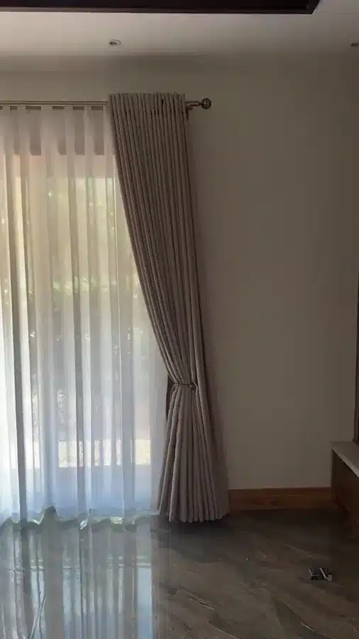A moving view of neutral curtains and white sheers around the room.