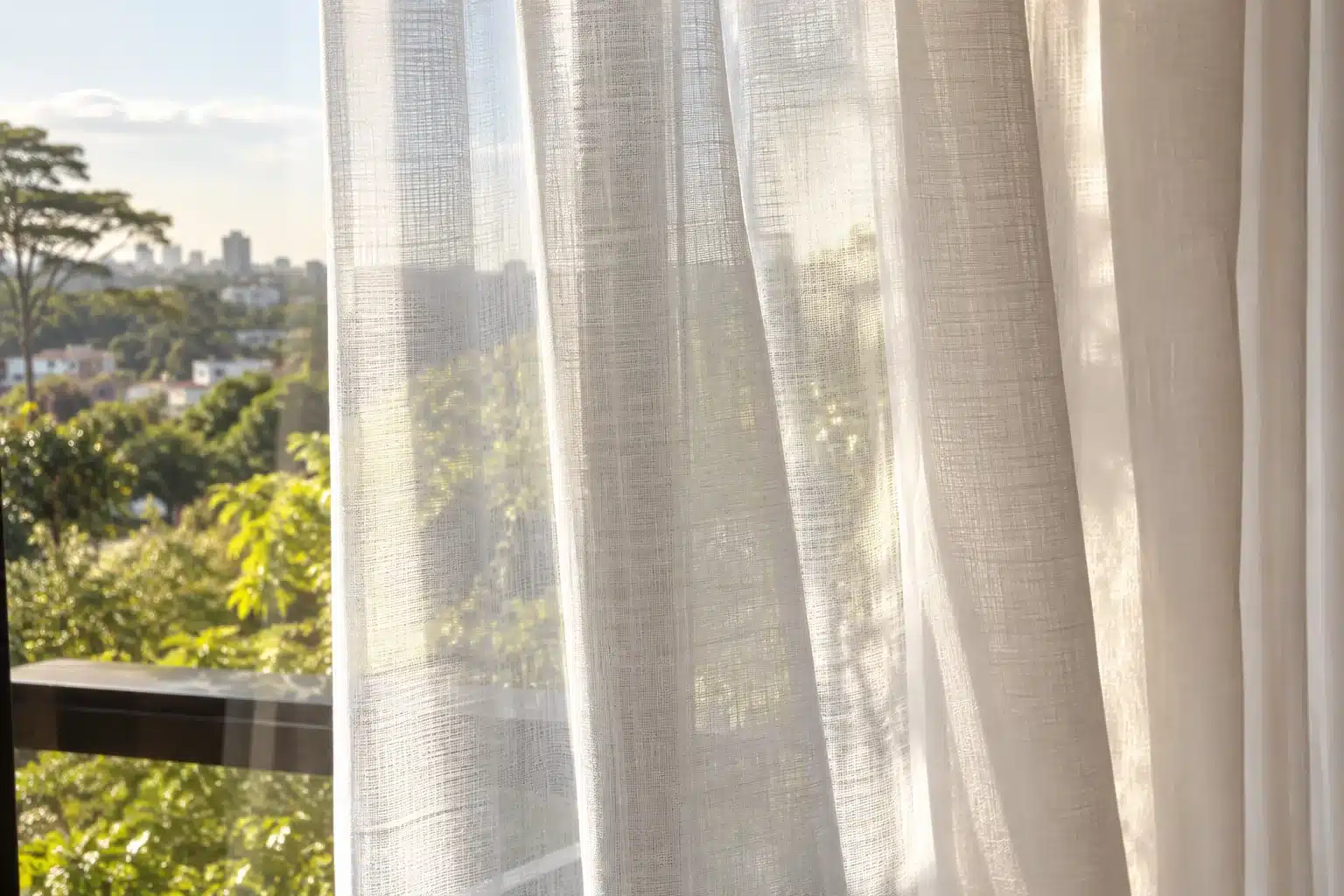 Sunlight filtered through the woven texture of a white sheer curtain